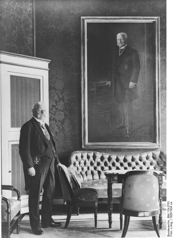 Reichspräsident Paul von Hindenburg mit Orden vor seinem Porträt