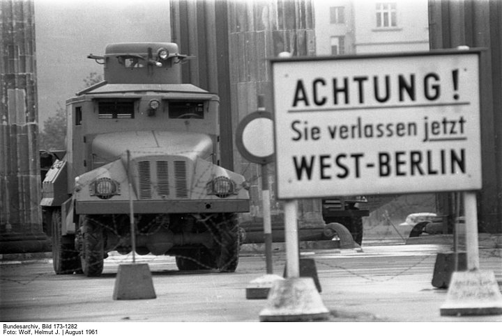 Hinweisschild "Achtung! Sie verlassen jetzt West-Berlin" vor dem Brandenburger Tor