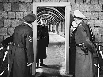 Ein Grenzsoldat der DDR im Gespräch mit Westberliner Grenzpolizisten und einer Krankenschwester am neu eingerichteten Grenzübergang Oberbaumbrücke, 21. Dezember 1963 