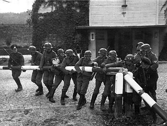 Danziger Polizisten und Grenzbeamte stellen am 1. September 1939 den Abriss des polnischen Schlagbaums an der Grenze zur Freien Stadt Danzig nach.
